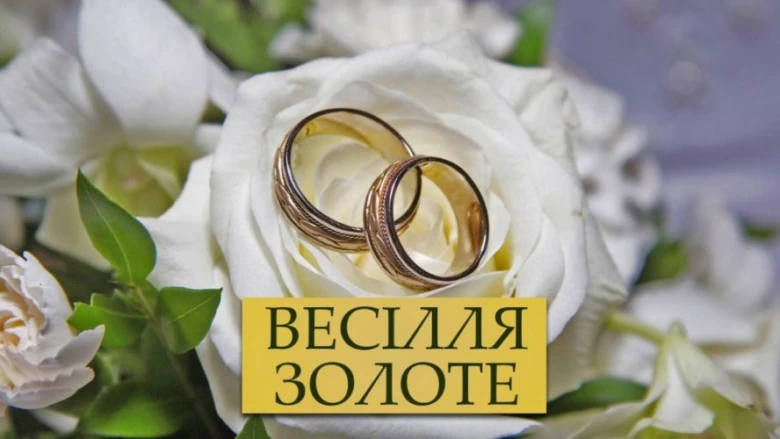 Біла троянда з двома золотими обручками та написом про золоте весілля.