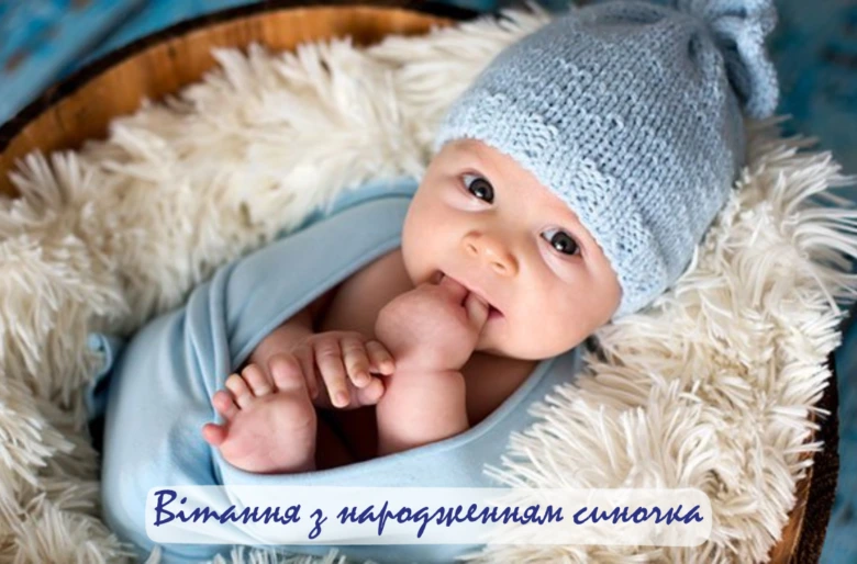 Новонароджений хлопчик у синій шапочці в кошику