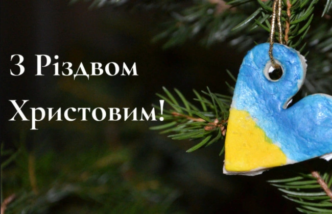 Синьо-жовте серце на ялинці з привітанням Різдва.