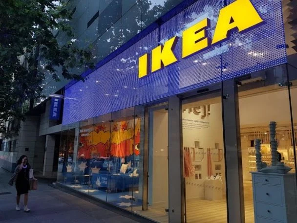 Зовнішній вигляд магазину ІКЕЯ з вивіскою та меблями у вітрині.