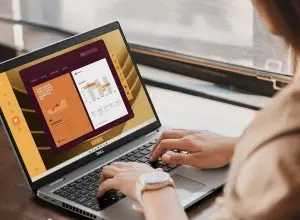 Людина працює на ноутбуці Acer біля вікна.